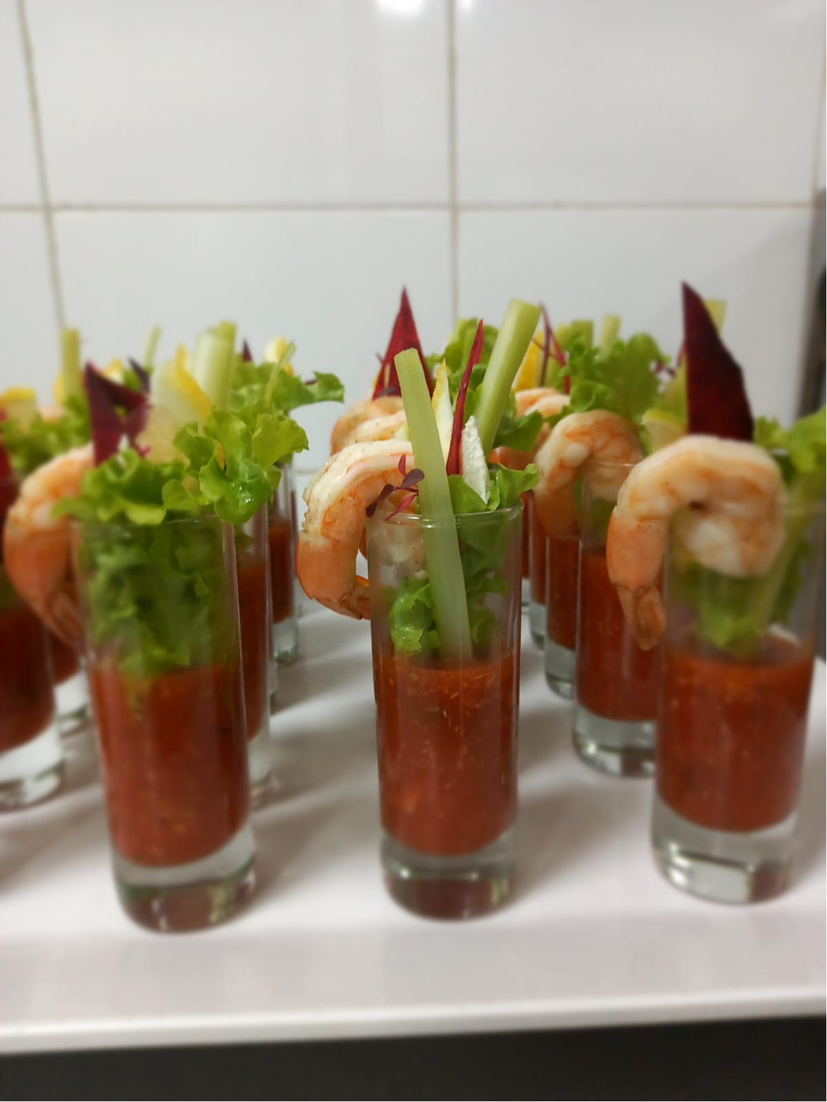 Shrimp cocktail shots with greens and crisp garnish served for events.